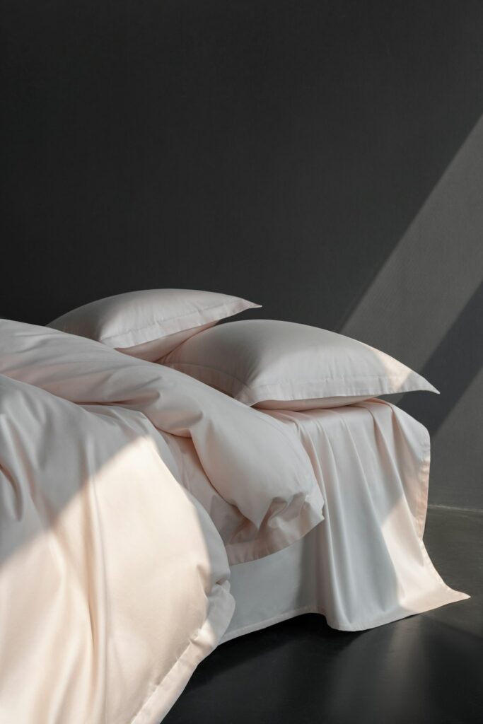 A bed with a white comforter and pillows