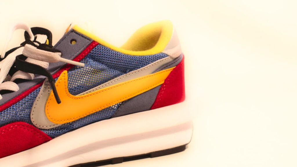A pair of sneakers with a yellow and blue shoelace